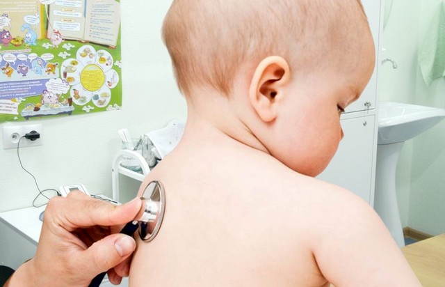Педиатр слушает стетоскопом лёгкие ребёнка